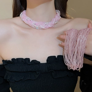 Macro shot of layered pink seed bead choker with white pearls and shimmering details