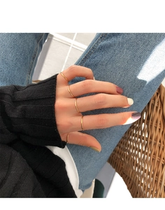 Close-up of minimalist thin gold stacking rings worn in a stylish layered arrangement