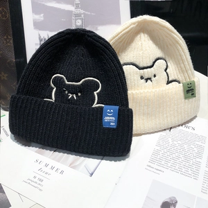 Winter knitted beanie hats with bear embroidery in black and beige tones