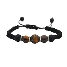 Macro shot of tiger eye stone beads and black braided rope with adjustable closure
