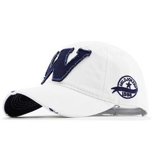 Détail d'une casquette blanche en coton avec applique W bleu marine et bordure effilochée