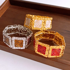 Macro detail of three vintage enamel square bracelets in gold and silver metal