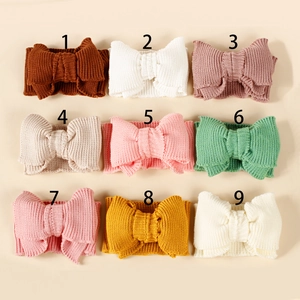 Macro view of elastic knitted baby headbands with large bows in nine soft colors