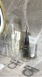 Wall-mounted toothbrush holder with inverted cups on marble wall in bathroom scene