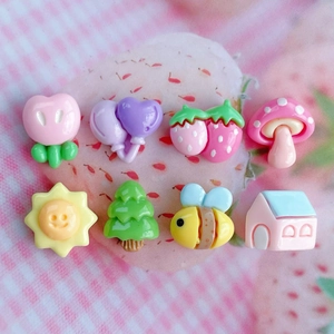 Flat lay of colorful resin charms including mushroom, bee, and house for DIY crafts