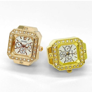 Detail of square ring watches in gold and rose gold with sparkling rhinestone bezels
