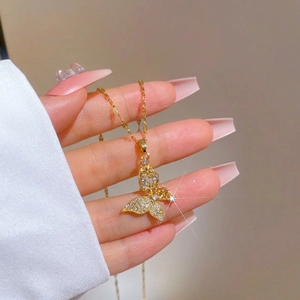 Luxury gold plated butterfly necklace with micro-paved zircons held by a model