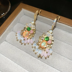 Detail of luxury teardrop fringe earrings with sparkling crystals and colorful gemstones