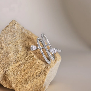 Detail view of silver iris ring with pear-shaped zircon on a natural stone base