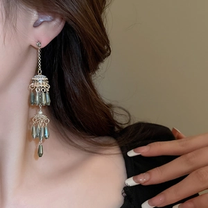 Detail of silver needle pearl tassel earrings with crystal water drop on model
