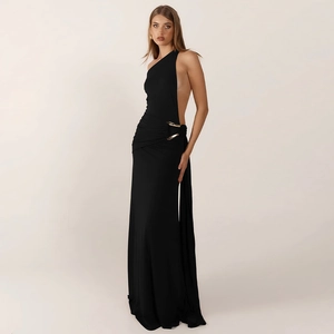 Détail d'une robe noire à une épaule avec boucles en métal doré décoratives à la taille