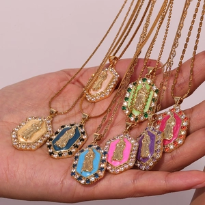 Hand holding colorful Virgin Mary pendants with enamel finish and sparkling zircons