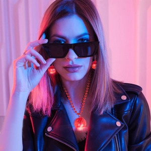 Luminous red disco ball earrings and necklace set worn by model in neon party lighting