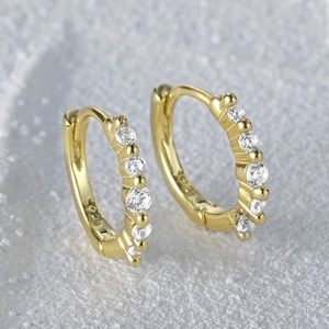 Detail shot of gold S925 sterling silver huggie earring with five round zircon stones