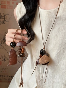 Détail d'un collier ethnique avec des disques en bois naturel et des graines sombres