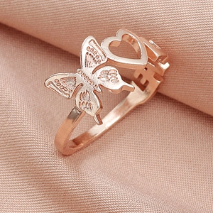 Detailed macro view of rose gold ring with heart and butterfly motifs on silk