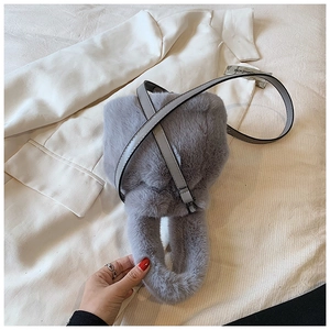 Détail de la texture en fausse fourrure grise et de la bandoulière en cuir du sac