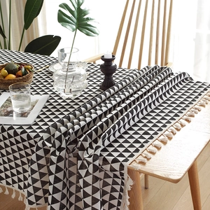 Close-up of linen table runner with black and white geometric patterns and tassels