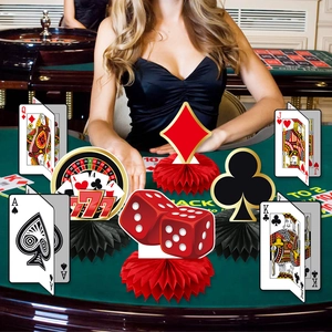 Casino theme party honeycomb centerpieces with poker cards and dice on green table