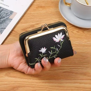 Black lychee leather mini bag with white floral embroidery and gold metal clasp closure