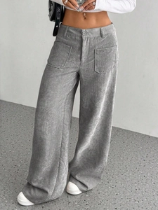 Dettaglio dei pantaloni larghi in velluto a coste grigio con texture e vestibilità ampia