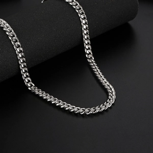 Classic silver stainless steel Cuban link chain necklace on premium black pedestal