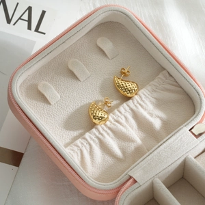 Textured gold drop earrings with grid pattern displayed in a pink jewelry box