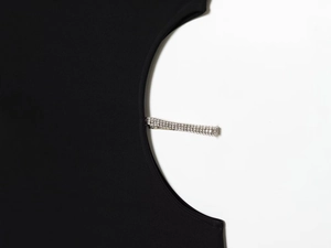 Detalle de vestido negro con recorte lateral decorado con tres filas de brillantes diamantes