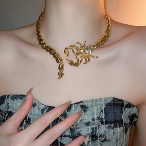 Close-up of a gold scorpion choker with crystal accents on a model for a bold fashion look