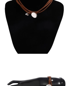 Double-layered brown leather choker necklace with silver oval pendant detail and wrist styling