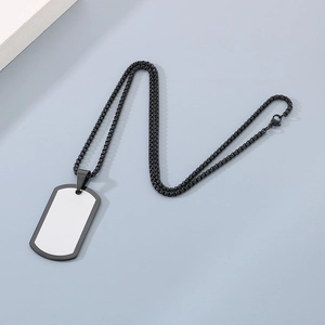 Macro detail of custom black dog tag necklace with white blank space for laser engraving