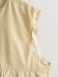 Détail des coutures fines et de l'épaule sur le haut sans manches plissé beige