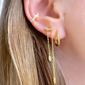 Elegant gold tassel earrings set with cubic zirconia crystals worn by a model