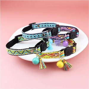 Adjustable plaid cat collar with bell and tassel in vibrant colors on a pink background