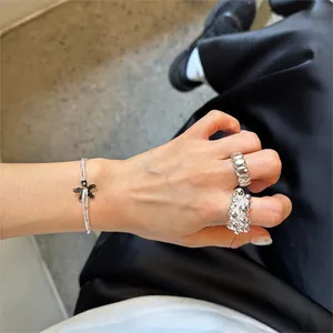 Detail of S925 sterling silver flower bracelet and ribbed ring on a model's hand
