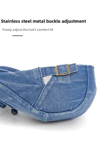 Detail of adjustable bronze stainless steel buckle on blue denim newsboy cap