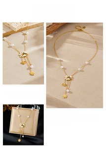 Dettaglio della collana con ciondolo ape dorata e fiori, perle bianche e smalto