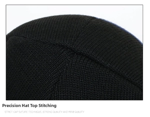 Detailed macro view of reinforced stitching on the crown of a black knit beanie