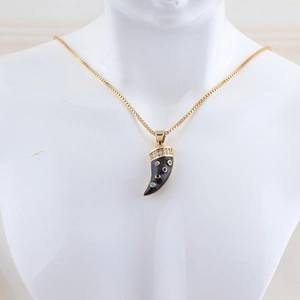 Detail of horn pendant necklace with black enamel and colorful zircon stones on mannequin