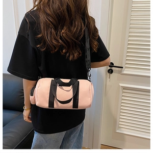 Rear view of a model carrying a pink nylon Boston bag showing its size and proportions