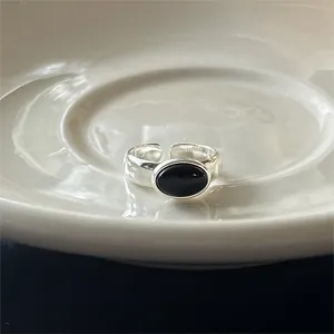 Detail of a 925 sterling silver open ring featuring an oval black onyx on a ceramic plate