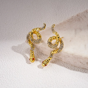 Detailed macro view of snake earrings with sparkling rhinestones and red stone eyes