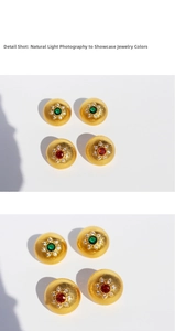 Macro detail of vintage brushed gold disc earrings with zircon halo and colorful center stone