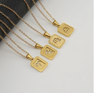 Detail of square gold zodiac pendants featuring hollow constellation symbols on O-chains