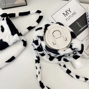 Detail of plush cow print water bottle bag featuring a soft texture and crossbody strap
