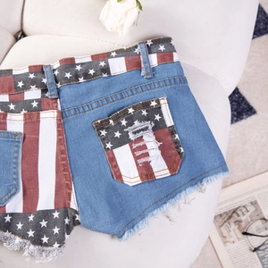 Dettaglio degli shorts in denim con bandiera, bordi sfrangiati e tasche con strappi