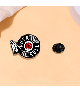 Detailed macro shot of a vintage rock vinyl record enamel pin with black rubber clutch