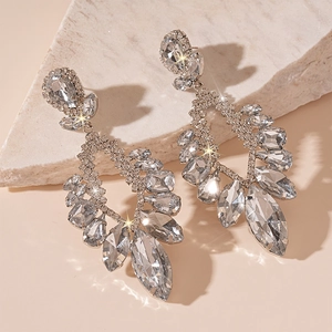 Detailed macro shot of silver flower drop earrings with sparkling rhinestones on stone