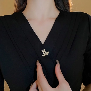 Elegant gold butterfly brooch with cubic zirconia and white stones on black fabric