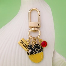 Macro shot of squirrel on acorn keychain with gold wish tag and red gemstone detail